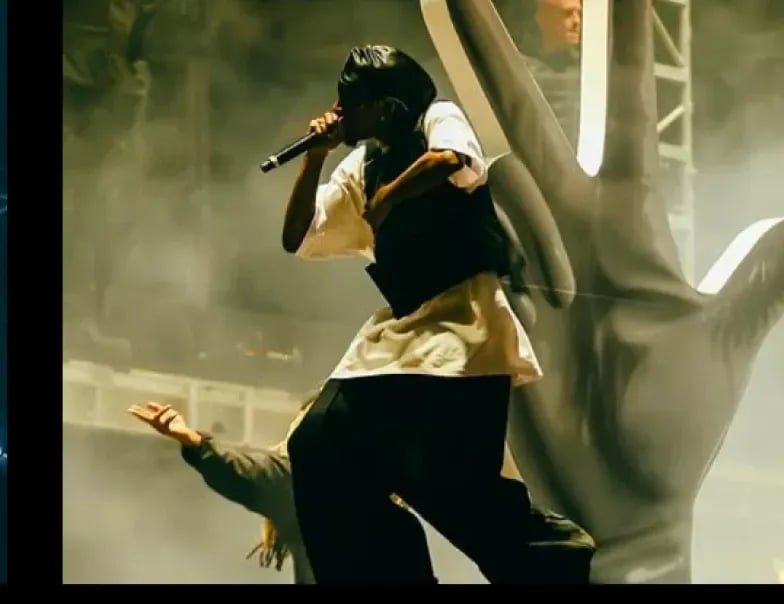 Playboi Carti performing on stage with a mic